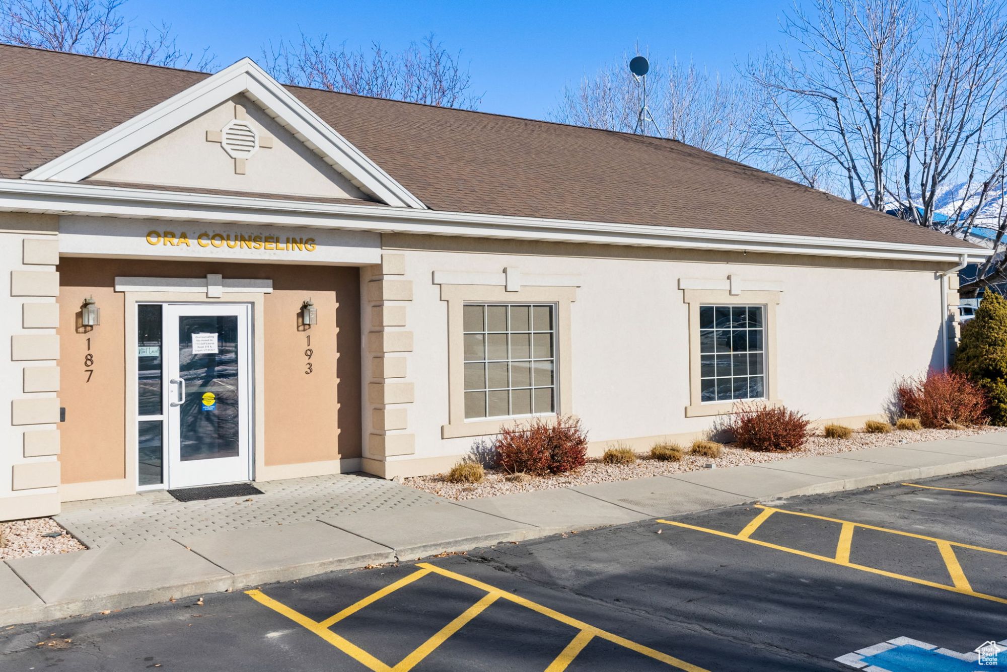 Front entrance of a single-story stucco office building in North Logan